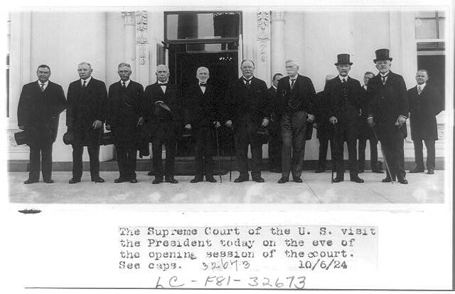 Nine justices of the United States Supreme Court posed standing outdoors with William Howard Taft on eve of opening session of the cour
